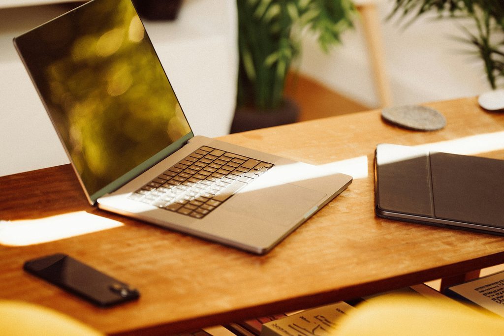 laptop, ipad en telefoon op een bureau